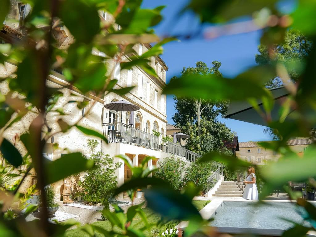 La façade en pierre blonde du Pavillon vue depuis la piscine