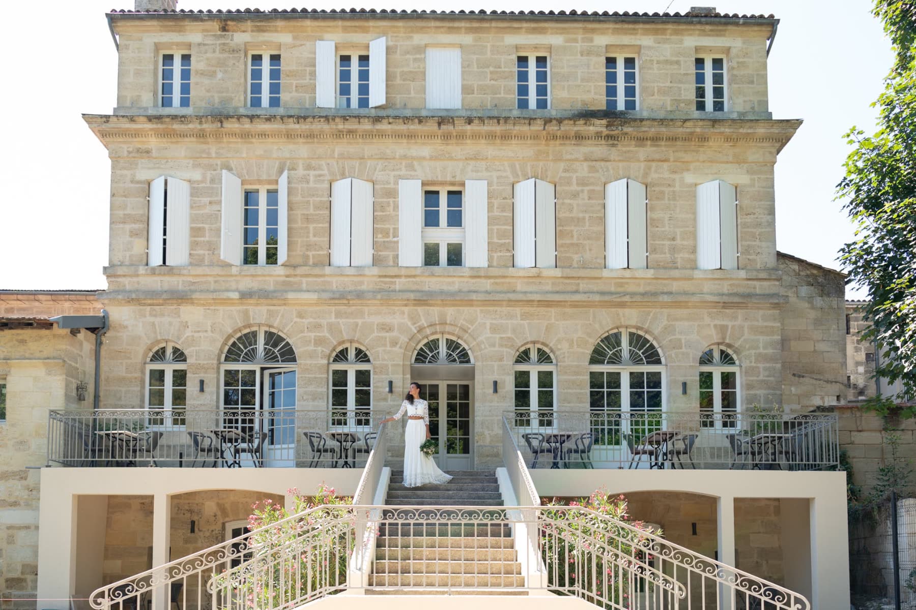 Façade en pierre de la bâtisse de 1882 du Pavillon des Millésimes au coucher du soleil, vignes de Saint-Émilion en arrière-plan
